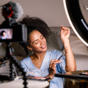 black female with camera and ring light. Recording a video